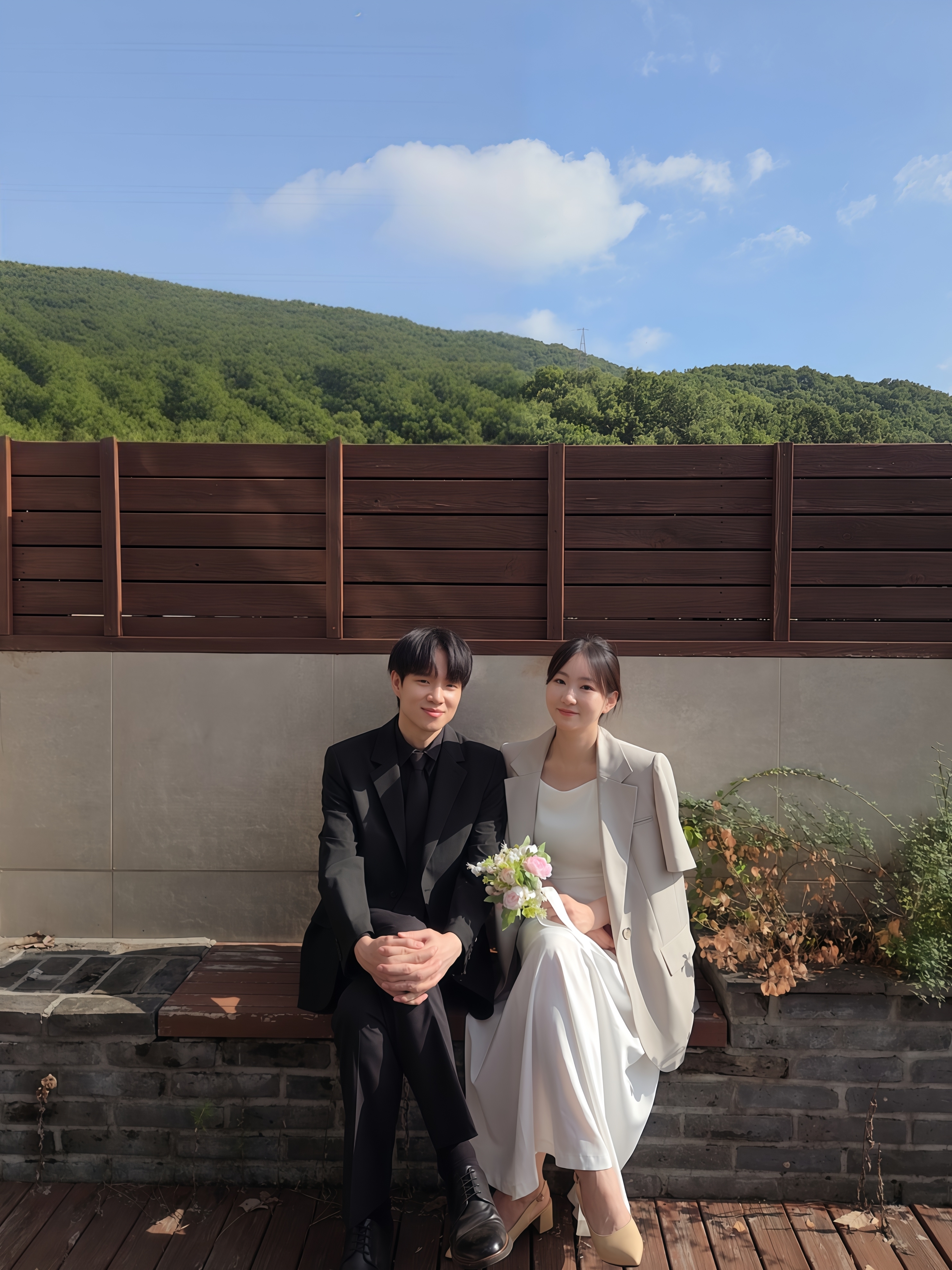 푸른 하늘 아래 함께 앉아 있는 원종범과 김희영